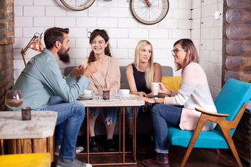 Friends drinking coffee in cafe, talking, having fun and relaxing