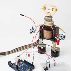 A metal robot and an electronic board that can be programmed. Robotics and electronics. Arduino in the school. Mathematics, engineering, science, technology, computer code. STEM education for kid. 