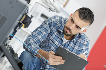 Naklejka na ściany i meble man technician repairing a printer at business place at work