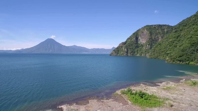 Aerial over Lake Amatitlan in Guatemala reveals the Pacaya Volcano in the distance.