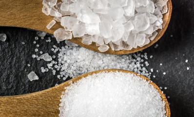 Different types of salt. Top view on two wooden spoons