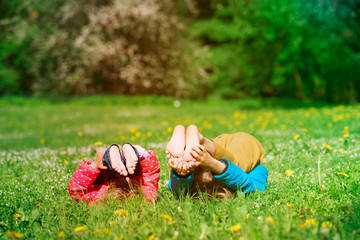 happy little boy and girl relax play in summer grass