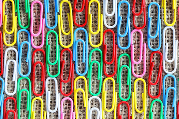 close up pattern of colorful paper clip on sack texture background.
