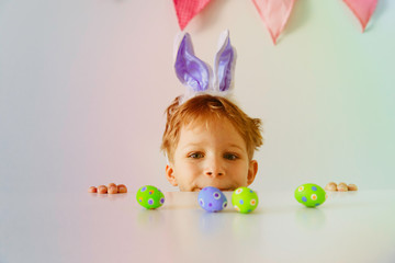 happy little boy play with eggs for easter