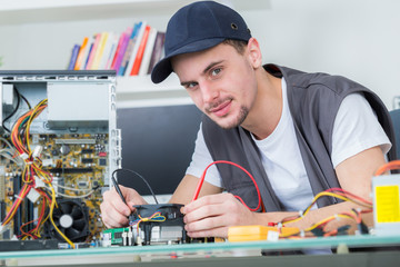 young male tech tests electronic equipment