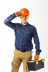 Portrait of repairman (builder) in helmet and with tool box in hands isolated on white background