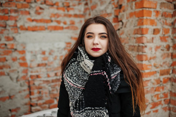 Brunette stylish casual girl in scarf against brick place.