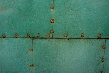 Surface from sheets of metal painted in green color fastened with nails