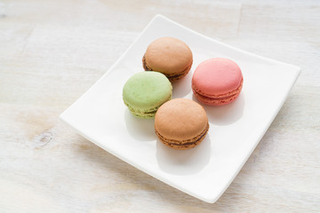 Four macarons on a white plate