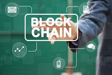 Businessman presses button blockchain idea on virtual electronic user interface.