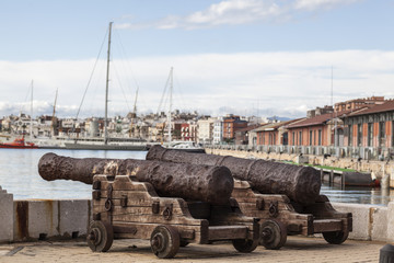 Fototapeta na wymiar Two old cannons in port of Tarragona, Catalonia, Spain.