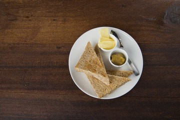 Slices of toast bread with butter on wooden table