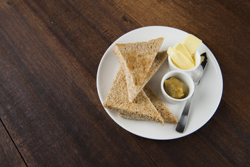 Slices of toast bread with butter on wooden table