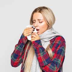 unhealthy female with paper napkin sneezing, experiences allergy symptoms, caught a cold, closed eyes. Sick woman has flu. Rhinitis, sickness, flu season