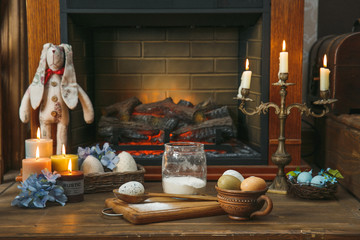 Easter, rabbit, eggs, candles, fireplace. Studio photo.