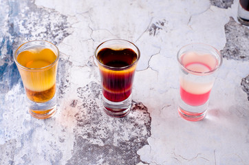 Set of strong alcoholic drink in shot glasses shooters, shots on background restaurant. Bar alcoholic cocktails menu into small glasses, long drink for party.