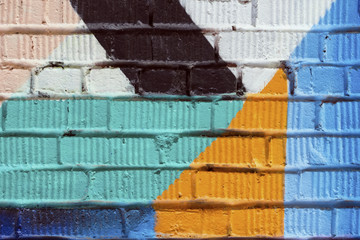 Abstract detail of brick wall with fragment of colorful graffiti. Urban Art close-up, for background use. © svetlanais