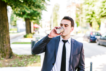Young businessman take break to drink coffee outdoor