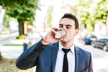 Young businessman take break to drink coffee outdoor