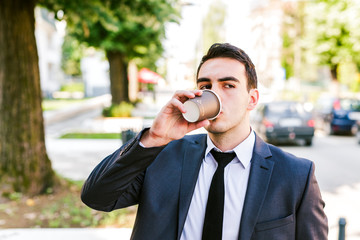 Young businessman take break to drink coffee outdoor