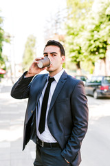 Young businessman take break to drink coffee outdoor