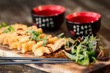 chinese food in a restaurant served on a wooden board