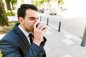 Young businessman take break to drink coffee outdoor