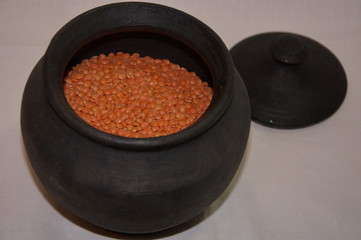 Dry red lentils in a black pot.