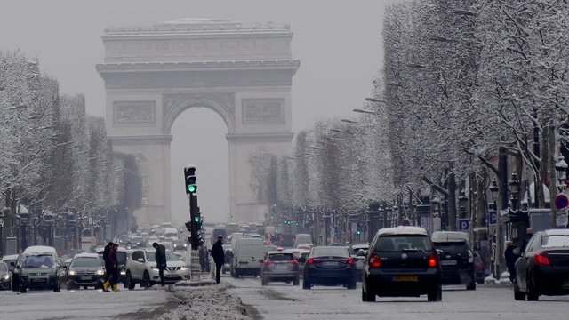 The arc de triumph by a rare snowy day in Paris, France