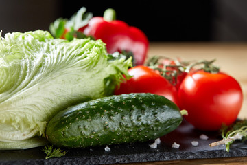 Organic closeup still life of assorted fresh vegetables and herbs on rustic wooden background, topview, selective focus.