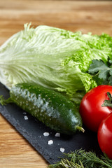 Organic closeup still life of assorted fresh vegetables and herbs on rustic wooden background, topview, selective focus.