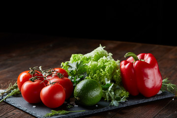 Vegetarian still life of assorted fresh vegetables and herbs on vintage wooden background, top view, selective focus.