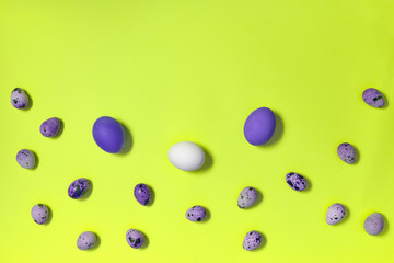 White, violet and quail easter eggs on yellow background, copy space. Healthy food concept. Top view, flat lay. Happy Easter concept
