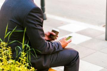 Young politician drinks coffee and use cellphone