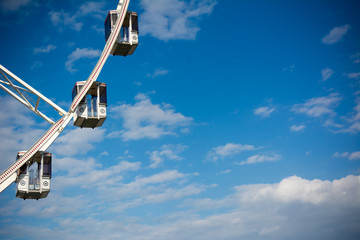 Horizontal View of a White Ferris Wheel on Partially Cloudy Sky Background. Copy Space. Bari, South of Italy