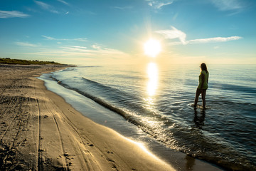 Sexy woman in sea sunset, beach in the summer sun rays, Baltic Sea, Poland