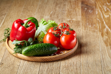 Artistic still life of assorted fresh vegetables and herbs on rustic wooden background, top view, selective focus.