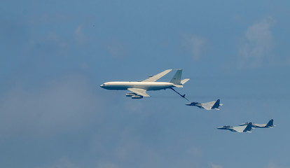 Fototapeta premium Izraelski myśliwiec i tankowiec podczas tankowania w powietrzu. Jets lecą od prawej do lewej w szyku.