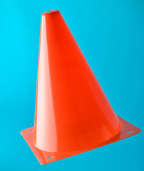 Orange cone, road barrier isolated on a blue background.