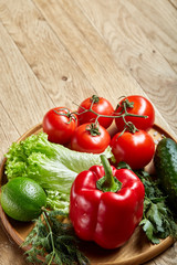 Artistic still life of assorted fresh vegetables and herbs on rustic wooden background, top view, selective focus.