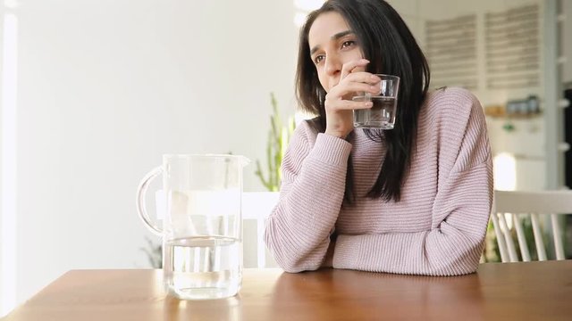 Pretty woman drinking water sitting in a cafe