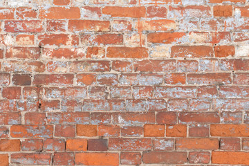 old brick wall with remnants of paint and plaster