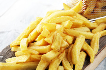 Tasty french fries on wooden table background