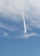 A beautiful blue sky with a dispersed streak of a flying airplane..