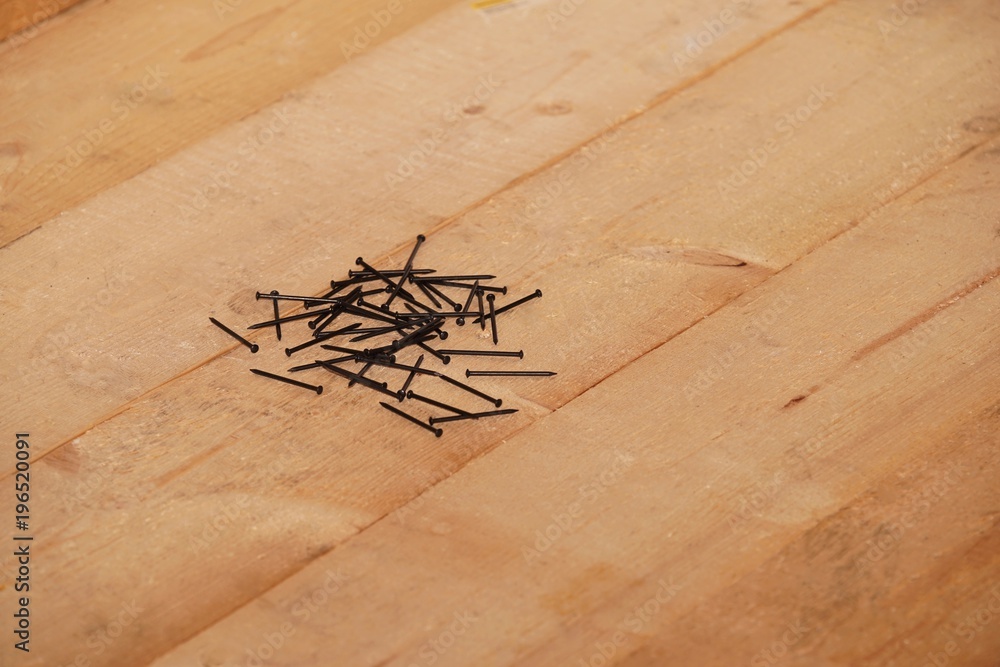 Wall mural Steel nails on a wooden floor
