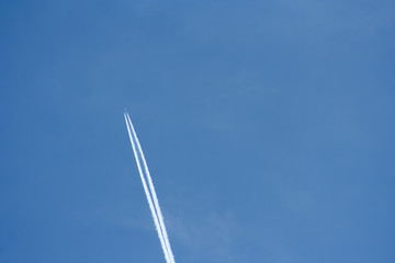 plane streak in the sky. Flying plane on the blue sky leaving behind white smoke