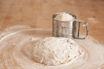 Raw wheat yeast dough on the table sprinkled with flour