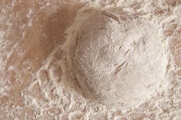 Raw wheat yeast dough on the table sprinkled with flour