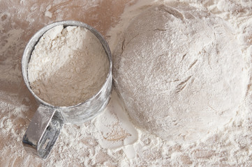Raw wheat yeast dough on the table sprinkled with flour