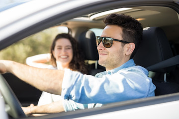 Young couple traveling by a car